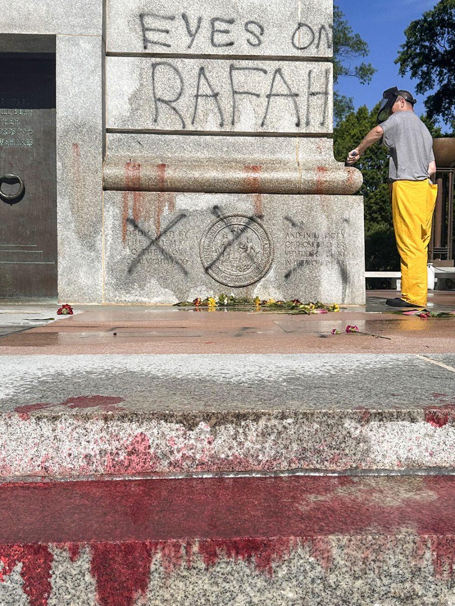 Work crews clean up graffiti spray-painted on the Memorial Belltower on Tuesday, May 28, 2024. Pro-Palestinian messages were spray-painted on the base and plaza, along with red paint to symbolize blood. NC State Police are investigating.