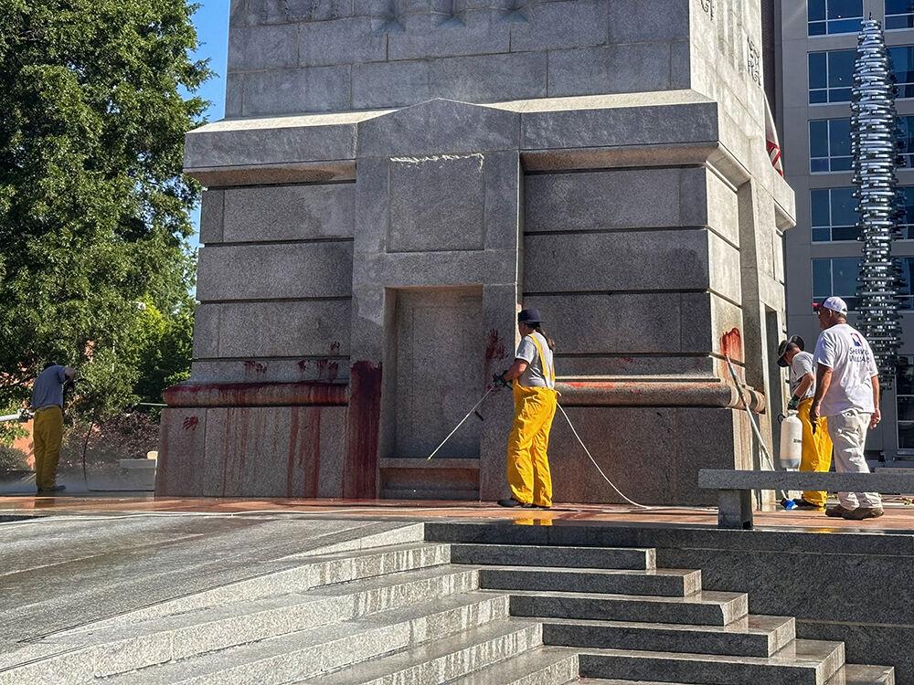 Work crews clean up graffiti spray-painted on the Memorial Belltower on Tuesday, May 28, 2024. Pro-Palestinian messages were spray-painted on the base and plaza, along with red paint to symbolize blood. NC State Police are investigating.
