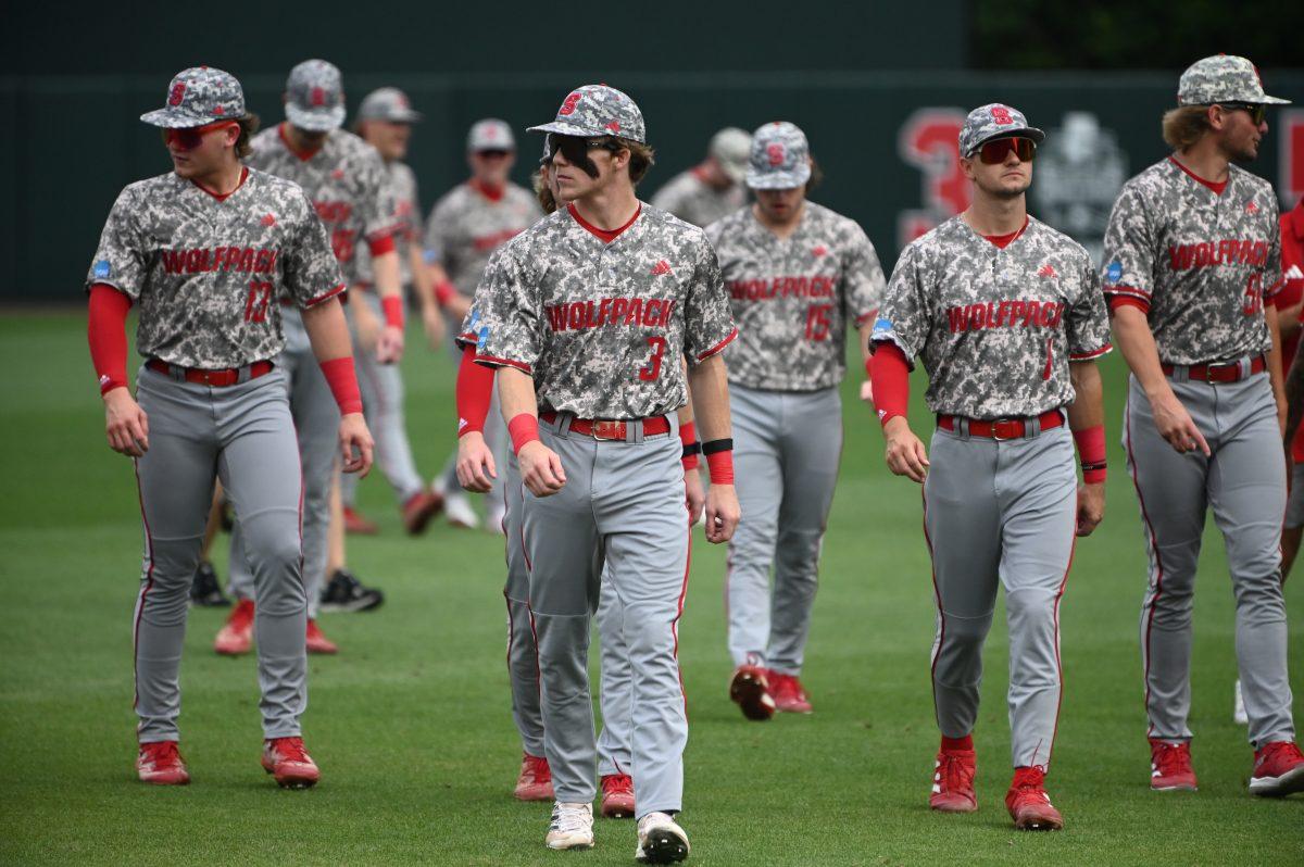 The NC State baseball team walks to the dugout after warm ups prior to the Wolfpack's game against the James Madison Dukes in the NCAA Raleigh Regional final on Doak Field at Dail Park on Sunday, June 2, 2024. The Wolfpack beat the Dukes 5-3 to advance to the super regional round in Athens, Georgia.