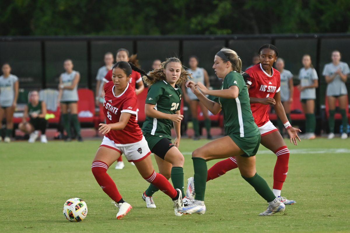 Freshman midfielder Mana Nakata dribbles away from defenders during NC State's home game against Charlotte at Dail Soccer Field on Thursday, Aug. 28, 2024. The Wolfpack beat the 49ers 3-1.