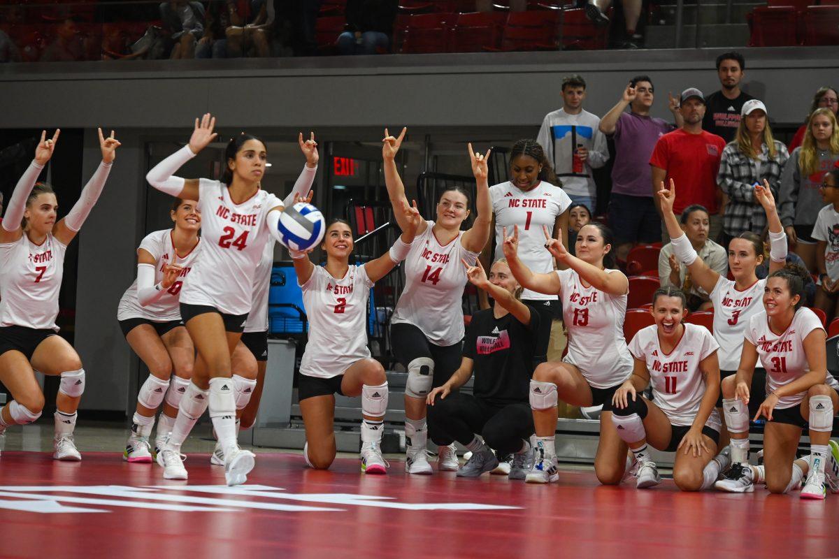 NC State's volleyball bench holds up wolfies on match poinit during the game against Virginia Tech in Reynolds Coliseum on Friday, Sept. 27, 2024. The Wolfpack beat the Hokies 3-0.
