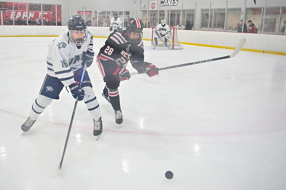 Sophomore forward Jake Gifford struggles to reach the puck during the game against the University of New Hampshire at Invisalign Arena on Friday, Oct. 18, 2024. NC State lost the game 4-3.