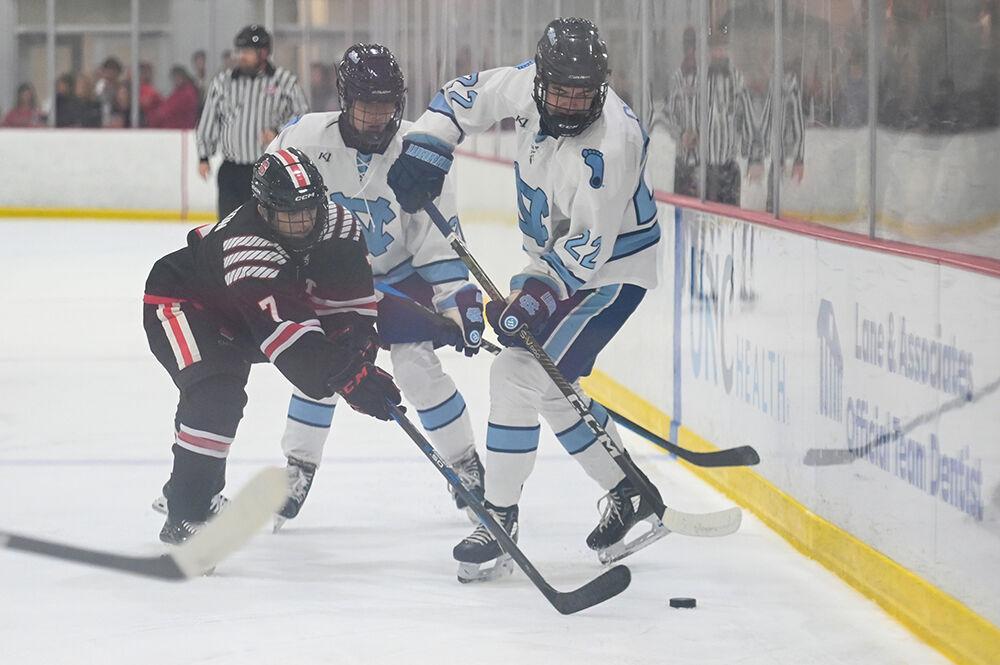 Senior forward Zack Robinson reaches for the puck during the game against UNC-Chapel Hill at Invisalign Arena on Friday, Oct. 11, 2024. The Wolfpack lost to the Tar Heels 6-5.