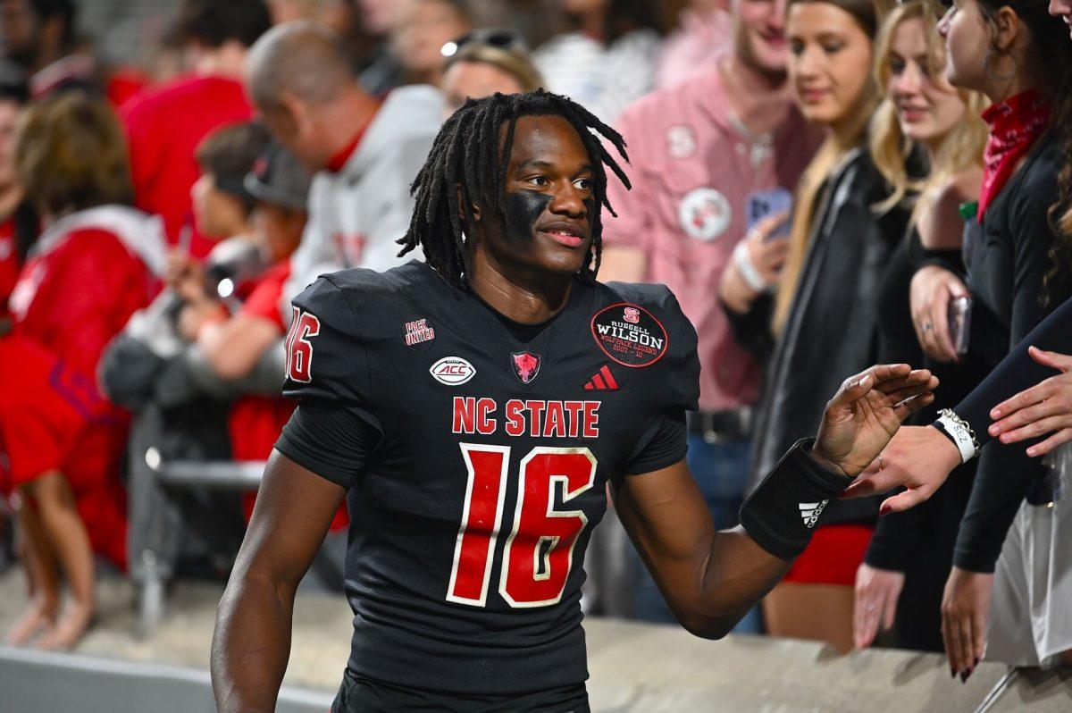 Freshman quarterback CJ Bailey high-fives fans after the football game against Duke at Carter-Finley Stadium on Saturday, Nov. 9, 2024. The Wolfpack lost to the Blue Devils 29-19. Bailey threw for 184 yards and recorded one passing touchdown.