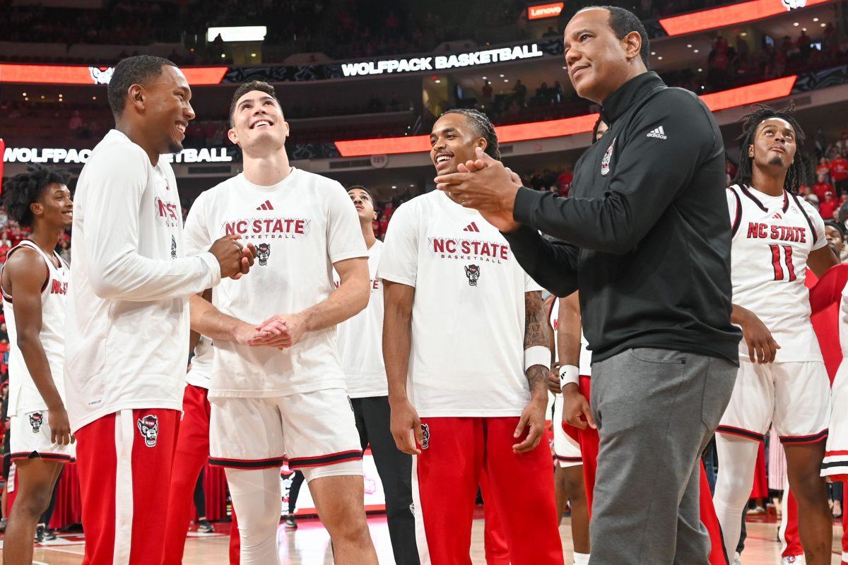 The NC State's Men's Basketball team smiles before the ACC Championship and Final Four banners are unveiled before the game against USC Upstate in the Lenovo Center on Monday, Nov. 11, 2024. The banners were revealed before the game, and now permanently hang in the Lenovo Center.