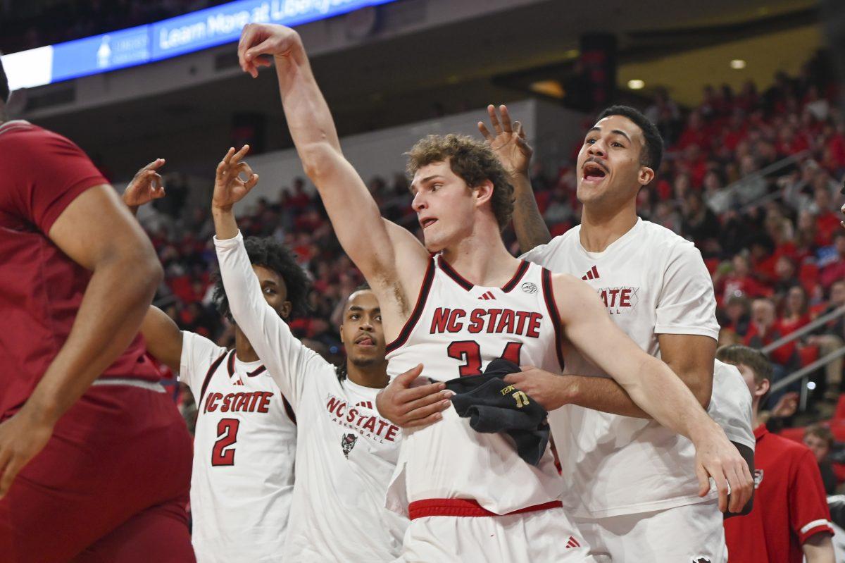 The NC State men's basketball team celebrates a three-pointer made by senior forward Ben Middlebrooks during the men's basketball game against Rider in the Lenovo Center on Sunday, Dec. 22, 2024. Middlebrooks made 100% of three-pointers attempted. NC State beat Rider 89-63.