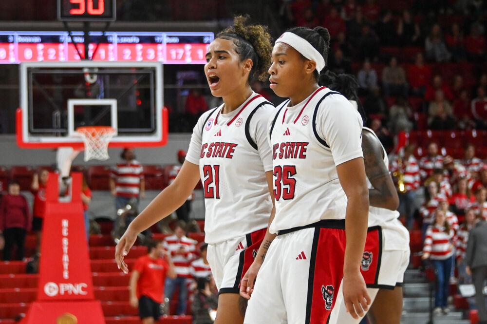 Graduate guard Madison Hayes (left) cheers after sophomore guard Zoe Brooks (right) both scored and was fouled during the game against Davidson College in Reynolds Coliseum on Wednesday, Dec. 11, 2024. The Wolfpack beat the Wildcats 59-57.
