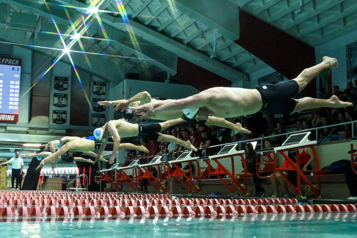 Swimmers jump into the water during the meet against UNC-Chapel Hill in Casey Aquatics Center on Friday, Jan. 17, 2025. NC State men defeated UNC men 165-134.