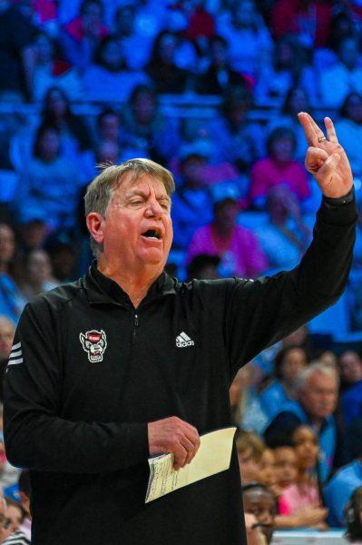 NC State women's basketball head coach Wes Moore holds up a three during the game against UNC on Sunday, Feb. 16, 2025 in Carmichael Arena. UNC defeated NC State 66-65
 