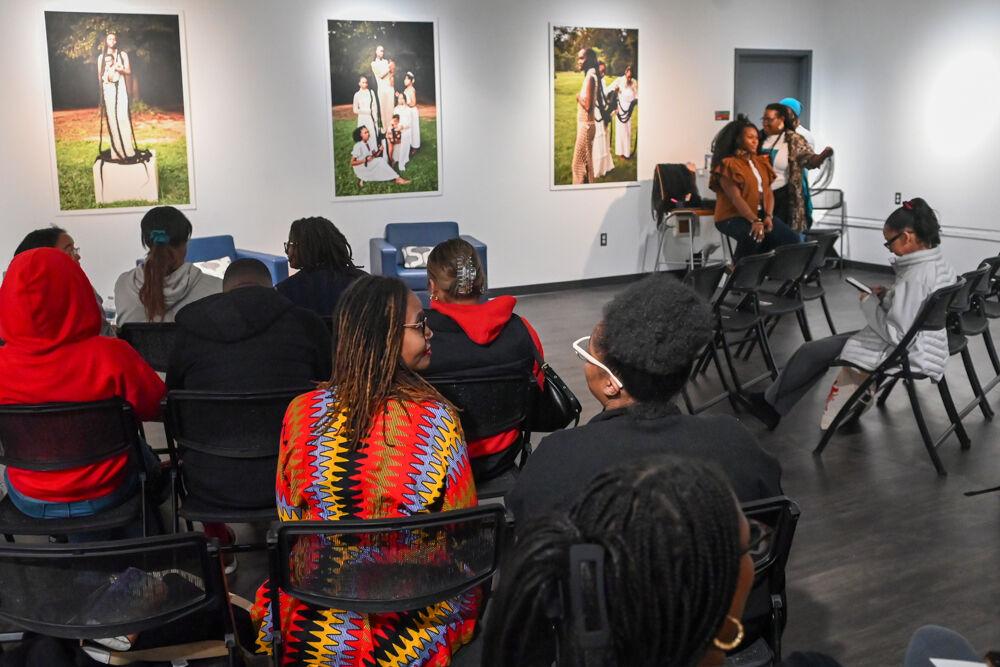 Attendees of the Crowning Glory Exhibit chat while waiting for the model walk to begin in the African American Cultural Center Art Gallery and Library on Thursday, Feb. 6, 2025. In the exhibit, the AACC showcased photography by local photographer and NC State alumna, Samantha Everette.