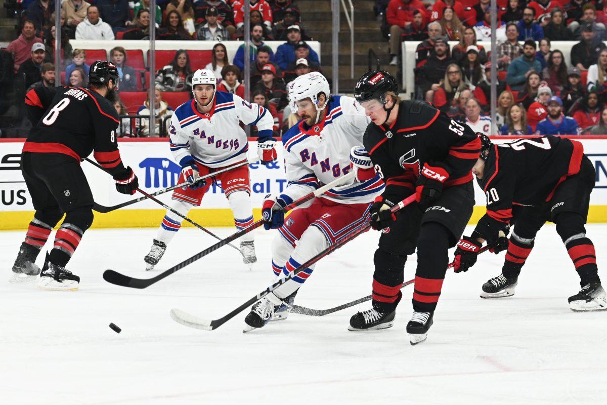 Right wing Jackson Blake battles an opponent for the puck during the game versus the New York Rangers at the Lenovo Center on Saturday, April 12, 2025. Blake scored one goal for the Hurricanes. The Hurricanes beat the Rangers 7-3.
