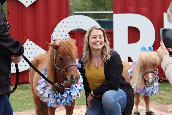 Graduate school employee Ashley Chilton takes a picture with Peaches the Mini Horse at The Corner on Centennial Campus on Tuesday, April 8, 2025. Peaches is a part of the Stampede of Love organization, a non-profit group dedicated to sharing the therapeutic benefits of animal therapy of adults and children.