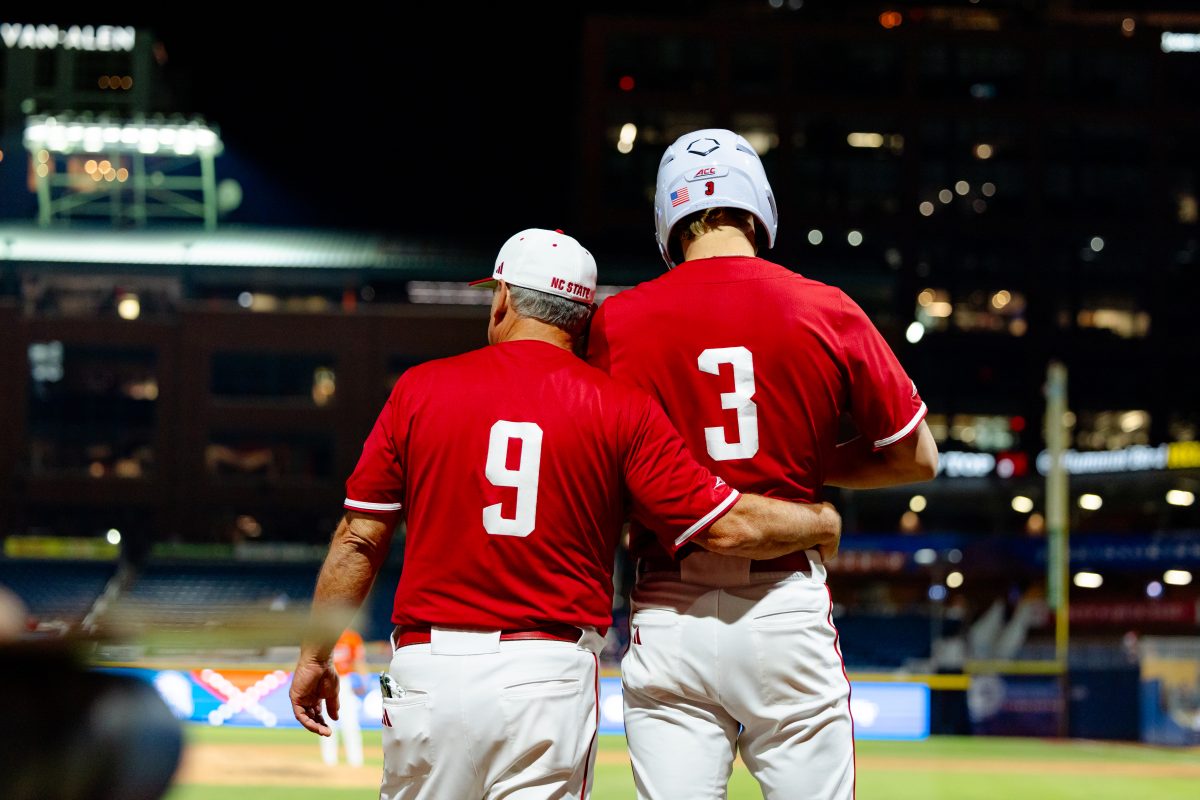Head Coach Elliot Avent wraps his arm around freshman infielder Ryder Woodson before sending him out as a pinch runner during the quarterfinals of the ACC Baseball Tournament against Clemson at Durham Bulls Athletic Park on Thursday, May 22, 2025. NC State lost to Clemson 7-6.