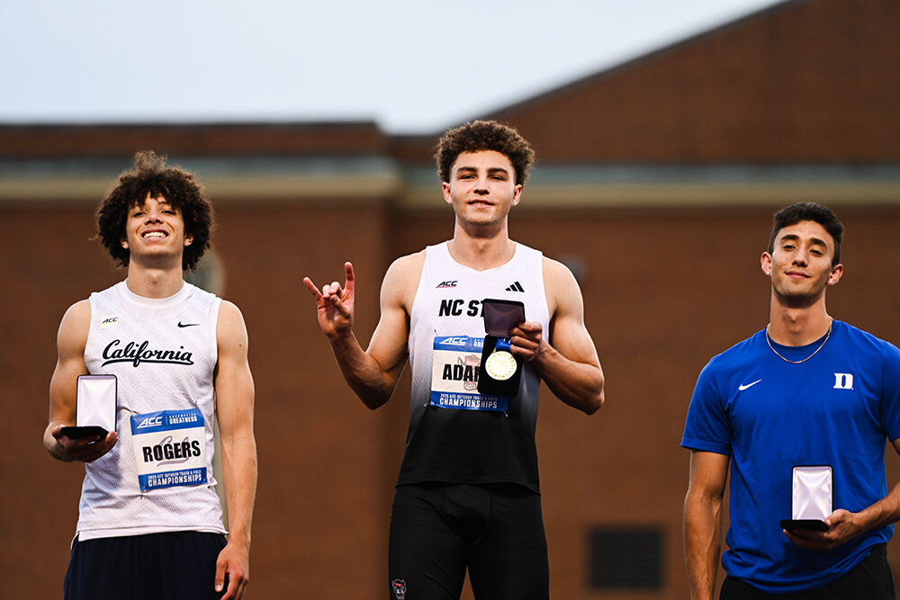 Sophomore jumper Tyson Adams holds up a "wolfie" after winning the men's long jump championship during the ACC Outdoor Track and Field Championships in Kentner Stadium on Friday, May 16, 2025. Adams placed first with a best jump of 7.69 meters.