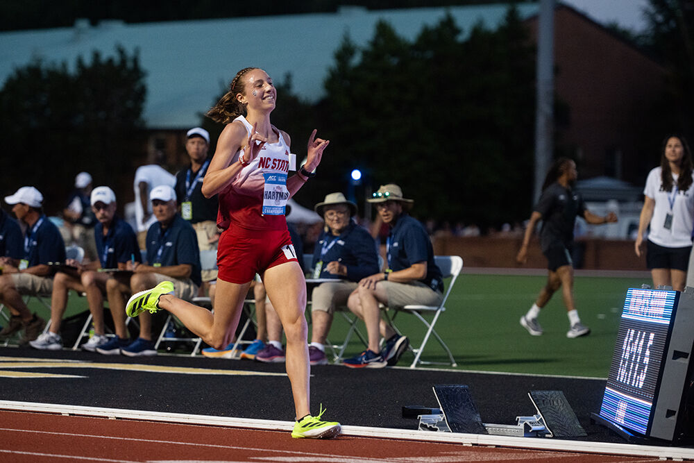 Junior distance runner Grace Hartman holds up "wolfies" as she crosses the finish line in the women's 5000m during the ACC Outdoor Track and Field Championships in Kentner Stadium on Saturday, May 18, 2025. Hartman won the championship and set a meet record with a time of 13:12.03.