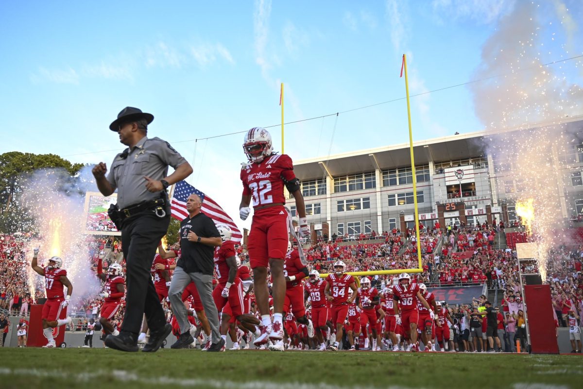 The NC State football team runs onto the field during the game against East Carolina at Carter-Finley Stadium on Thursday, Aug. 28, 2025. NC State beat ECU 24-17.
