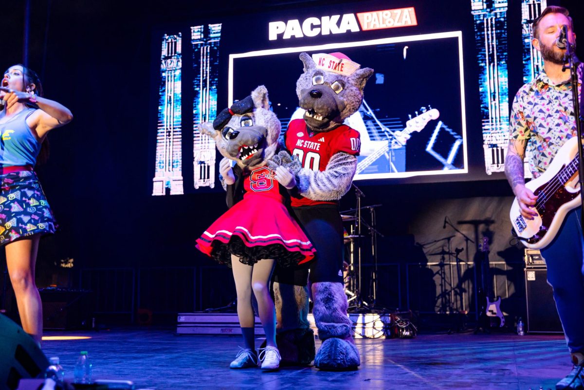 Mr. and Mrs. Wuf dance together onstage with Saved by the '90s during the Packapalooza concert on Saturday, Aug. 23, 2025. The concert served as the centerpiece of Packapalooza, drawing thousands to Hillsborough Street for the festival's finale.