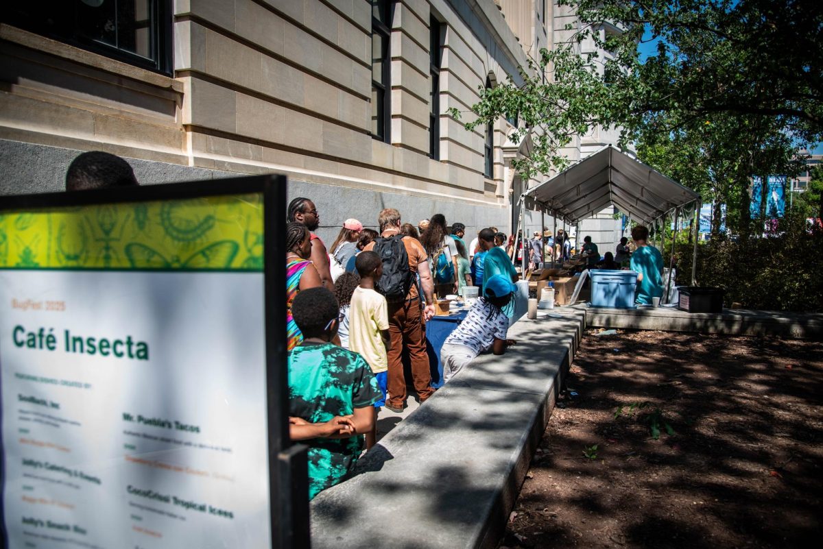 Visitors line up to receive insects from "Café Insecta" during BugFest at the North Carolina Museum of Natural Sciences on Saturday, Sept. 20, 2025. At BugFest, many vendors and conservationists set up stations to educate about the bug world.