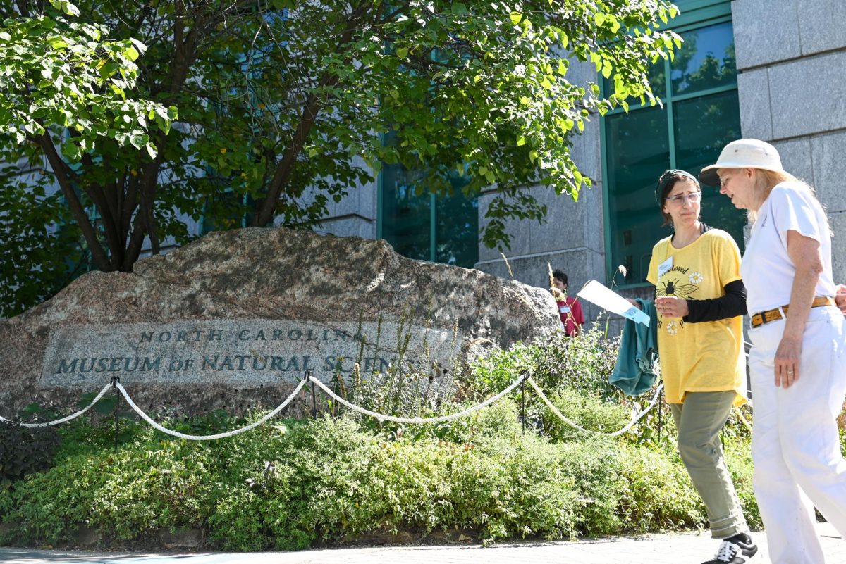 Festival goers walk past the sign for the North Carolina Museum of Natural Sciences sign during BugFest in Downtown Raleigh on Saturday, Sept. 20, 2025. Various booths were hosted during this event, including various NC State organizations.