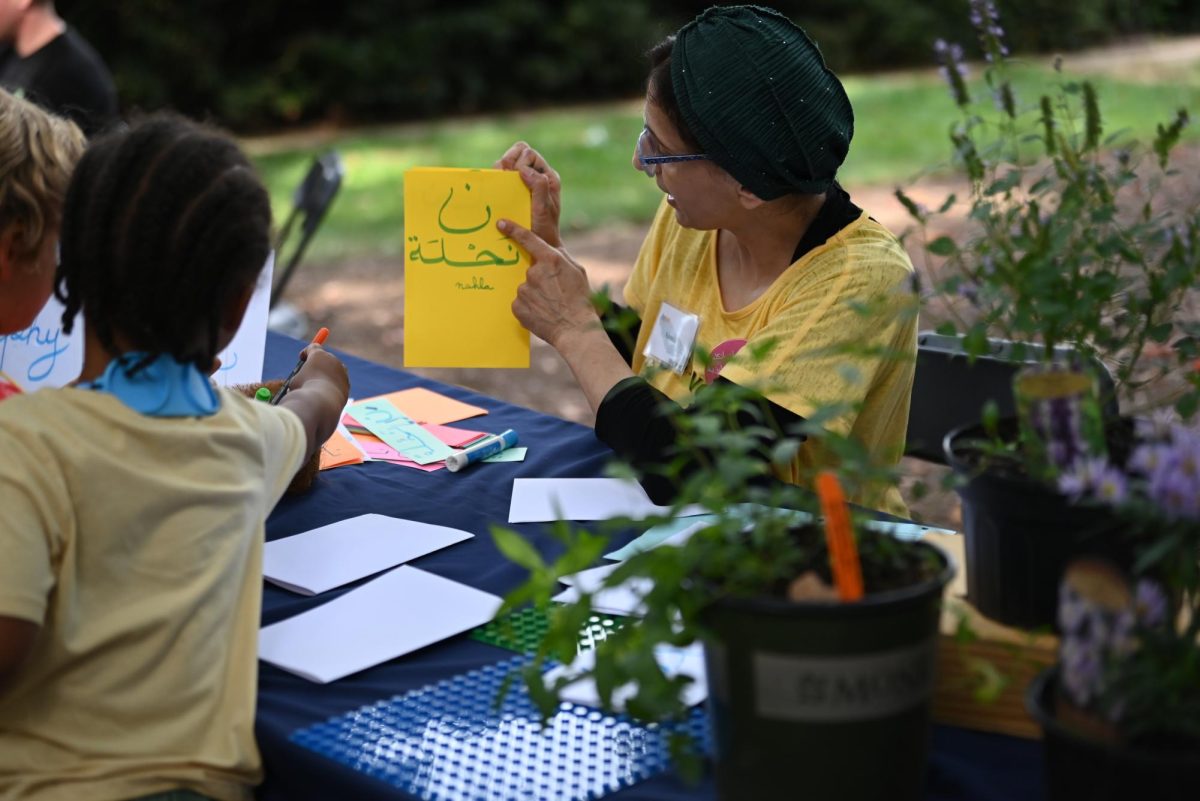 Samia Touati, a volunteer, teaches Arabic caligraphy at the Raleigh Museum of Natural Science at Bugfest on Saturday, Sept 20, 2025. The event was open to the public with food trucks, vendors and volunteers.
