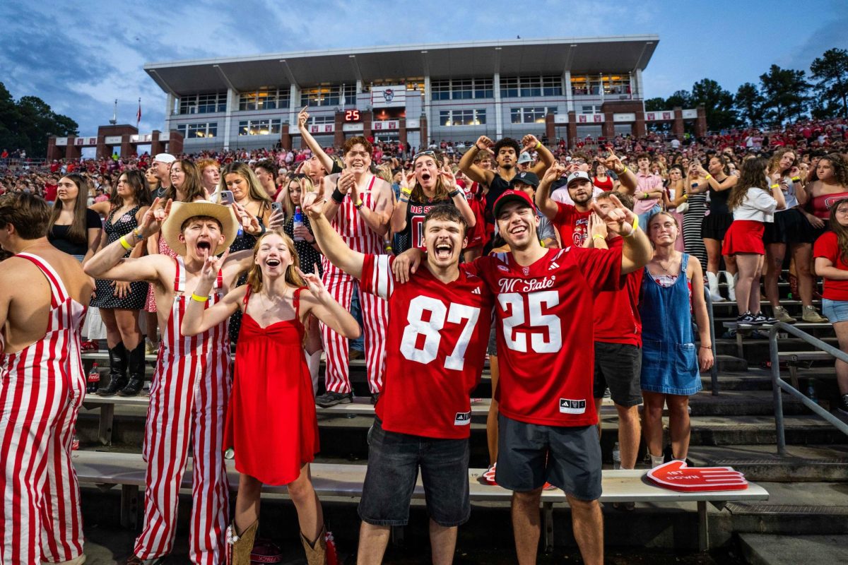 NC State students cheer in the student section while holding up the "wolfie" hand sign during the game against Virginia Tech on Saturday, Sept. 27, 2025.  NC State lost to Virginia Tech 23-21.