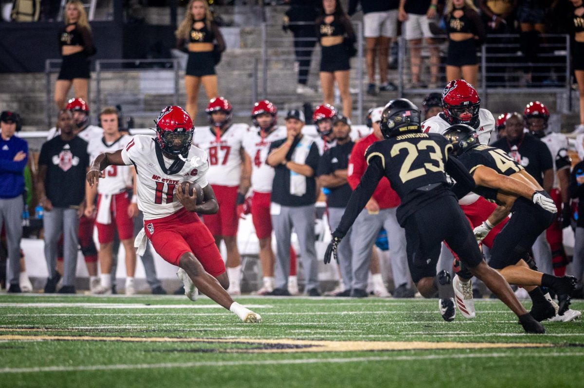 Sophomore quarterback CJ Bailey evades the defense during the game against Wake Forest in Allegacy Stadium on Thursday, Sept. 11, 2025. Baliey threw for 201 yards and three touchdowns. The Wolfpack beat the Demon Deacons 34-24.