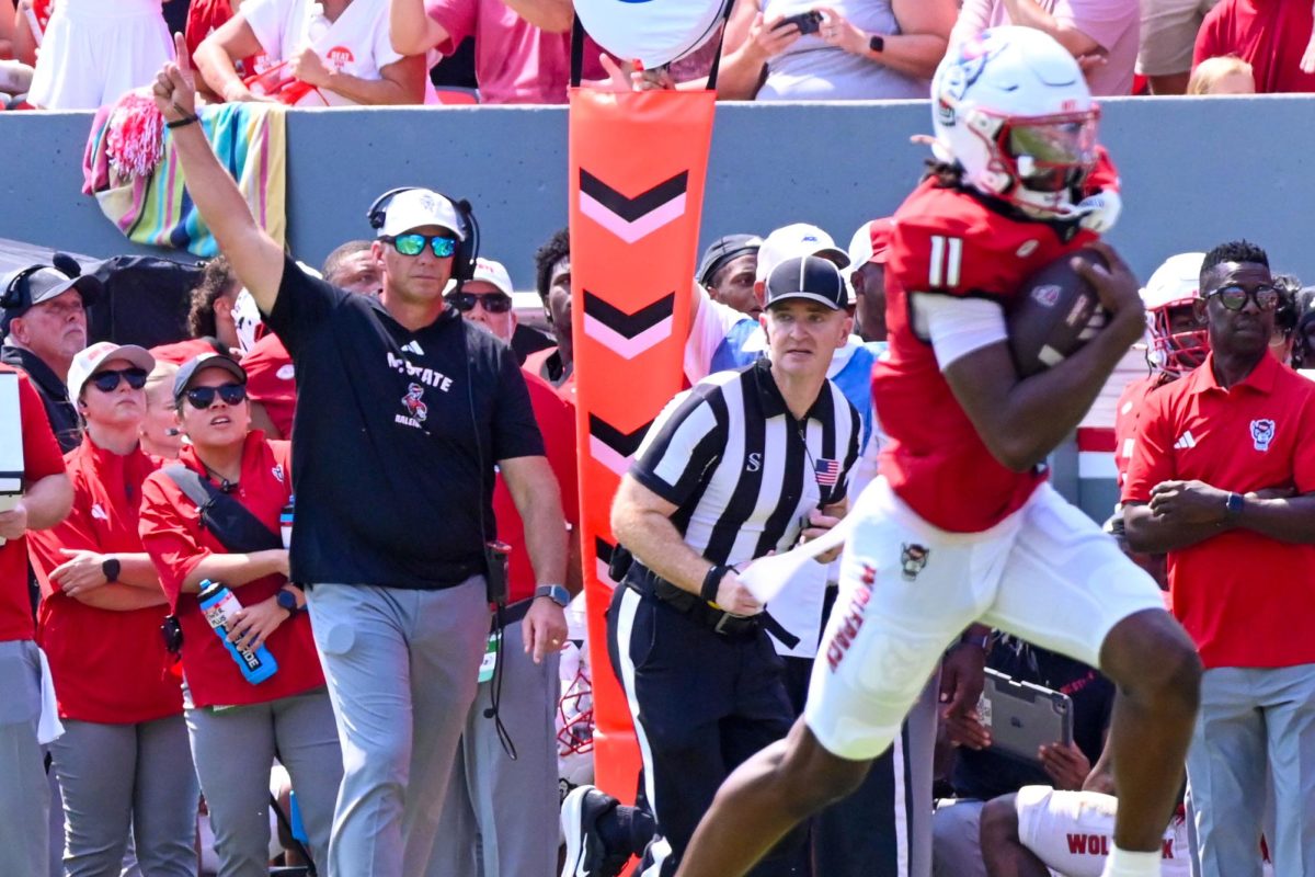 Head coach Dave Doeren points to the sky as sophomore quarterback CJ Bailey scores the rushing touchdown during the football game against Virginia at Carter-Finley Stadium on Saturday, Sept. 6, 2025. Bailey passed for a total of 200 yards and recorded two rushing touchdowns and one passing touchdown. The Wolfpack defeated the Cavaliers 35-31. 