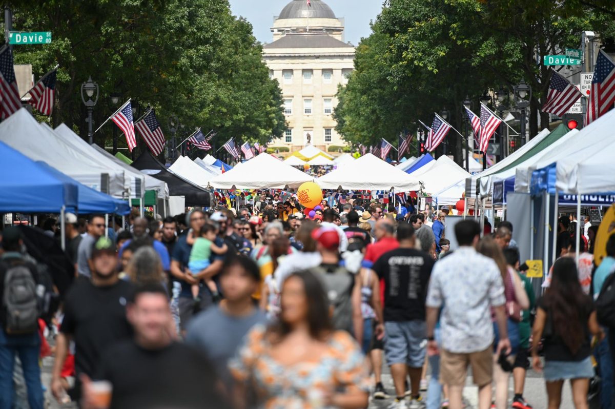 Festivalgoers celebrate and enjoy performances during La Fiesta del Pueblo at Fayetteville Street Historic District on Sunday, Sept. 21, 2025. The event, which draws thousands annually, is organized by El Pueblo to celebrate the pride and resilience of the Latine community.