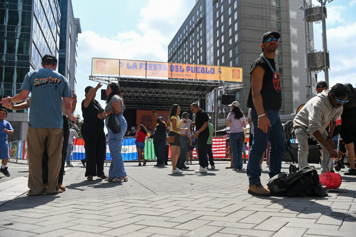 Festivalgoers gather around the stage as performers prepare to take the stage during La Fiesta del Pueblo at Fayetteville Street Historic District on Sunday, Sept. 21, 2025. The event, which draws thousands annually, is organized by El Pueblo to celebrate the pride and resilience of the Latine community.