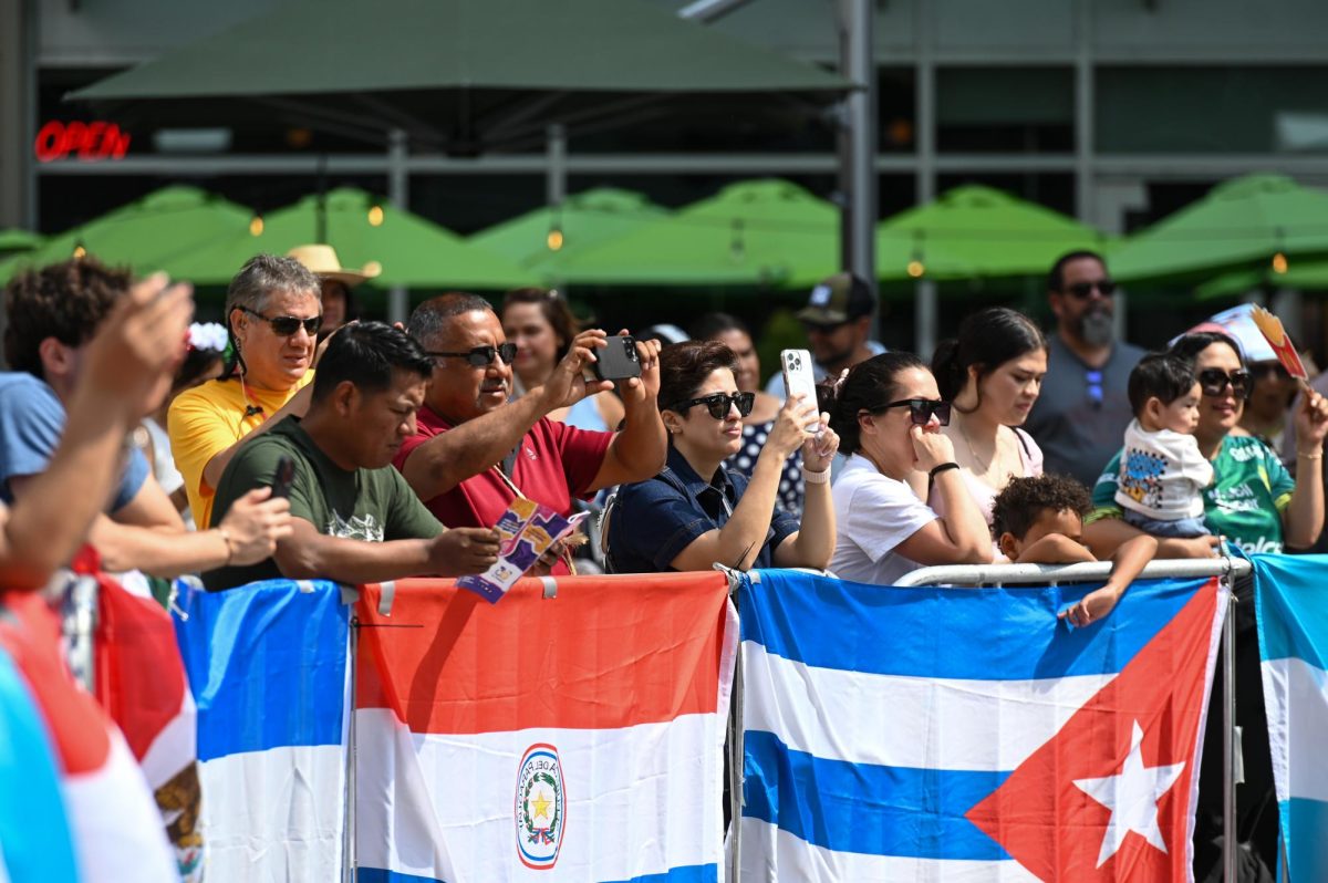 Festivalgoers watch as the folklorico club at NC State performs on stage during La Fiesta del Pueblo at Fayetteville Street Historic District on Sunday, Sept. 21, 2025. The event, which draws thousands annually, is organized by El Pueblo to celebrate the pride and resilience of the Latine community.