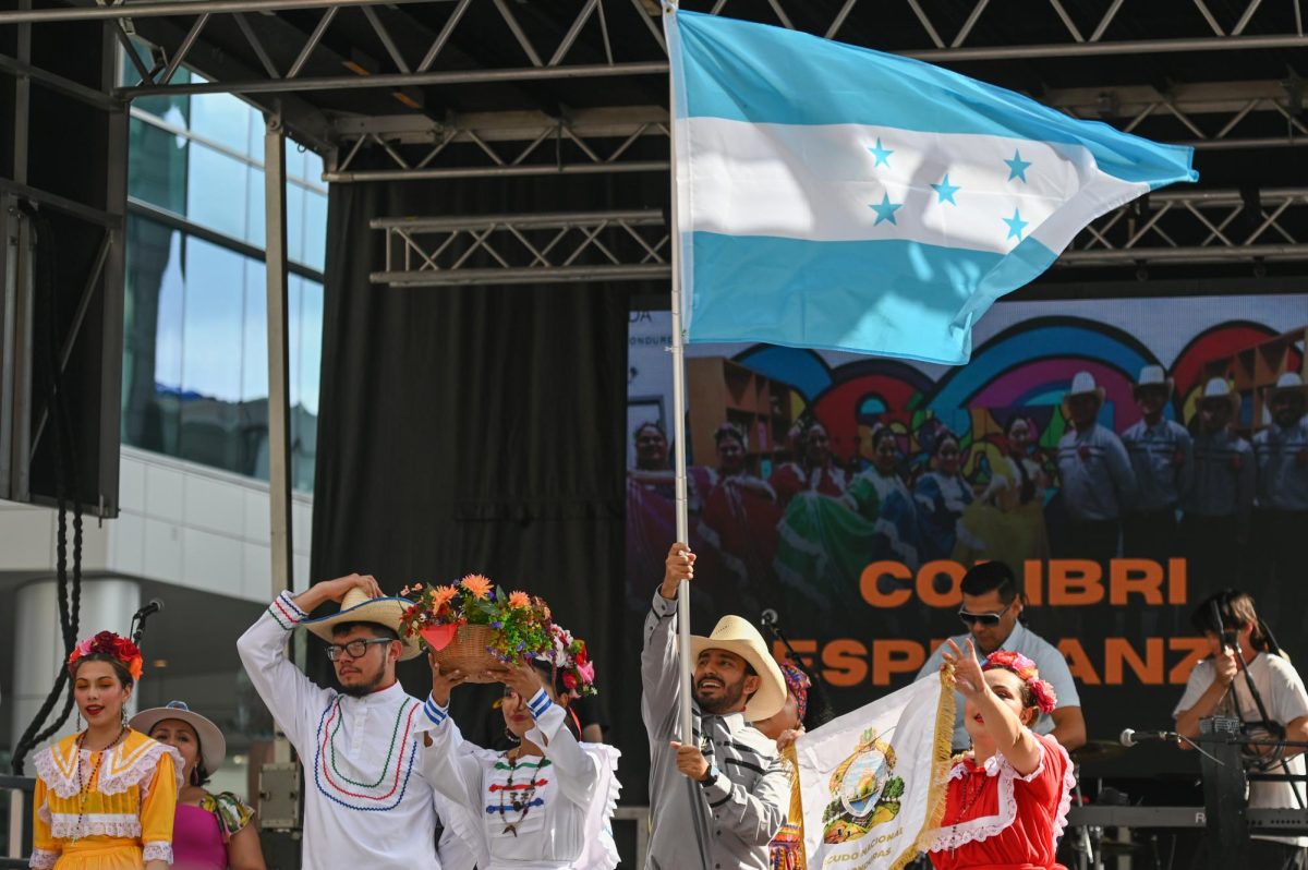 Honduran folklórico dance group Colibrí Esmeralda present the Honduran flag and emblem during La Fiesta del Pueblo at Fayetteville Street Historic District on Sunday, Sept. 21, 2025. The event, which draws thousands annually, is organized by El Pueblo to celebrate the pride and resilience of the Latine community.