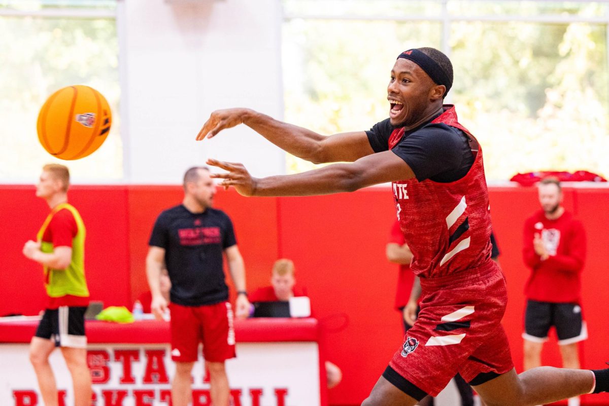 Senior guard Tre Holloman smiles while passing the ball during the first official practice of the 2025-2026 season on Monday, Sept. 22, 2025, inside the Dail Basketball Center. The media session offered reporters a closer look at the Wolfpack as preparations for the new season began.