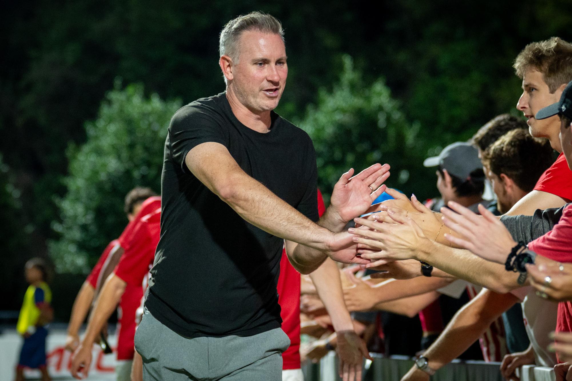 Head coach Marc Hubbard gives members of the Red Terrors high-fives after the game against FAU in Dail Soccer Stadium on Saturday, Sept. 13, 2025. The Wolfpack defeated the Owls 2-0.