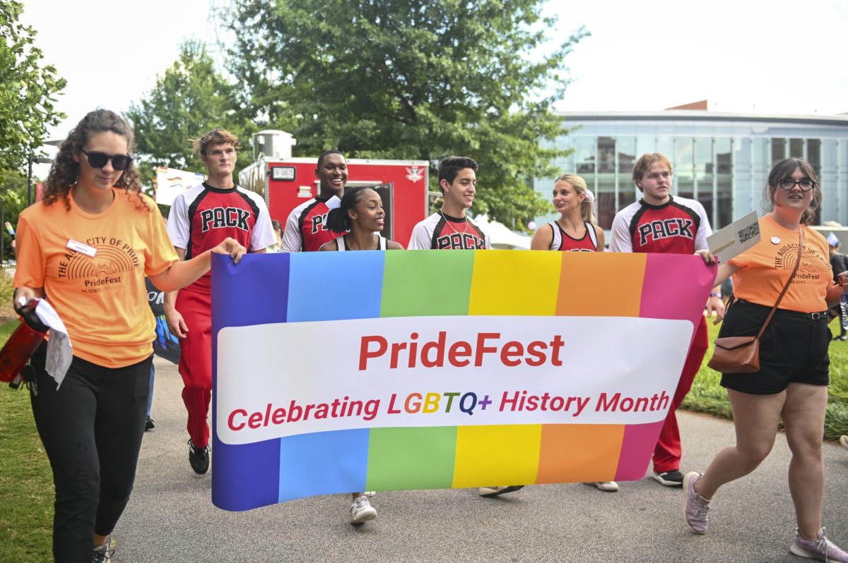 Volunteers and members of the NC State cheerleading team march around campus during PrideFest on Tuesday, Oct. 3, 2023. Formerly known as Pride Walk, the third annual PrideFest is an event meant to recognize the LGBTQ+ members of the Wolfpack and their allies.