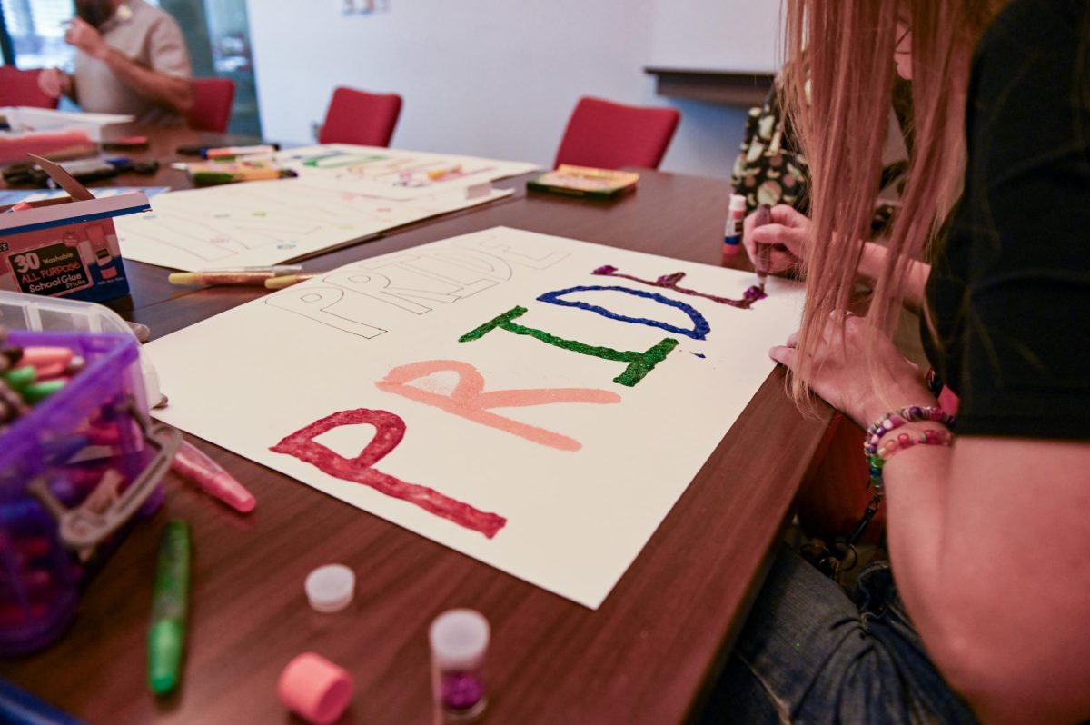 Kelly McConkey, a counselor at The Counseling Center, paints in glitter at the PrideFest poster-making event at Talley Student Union on Wednesday, Sept. 24, 2025. The poster-making event is one of the events the Pride Center holds to prepare for PrideFest, which is on Oct. 7.