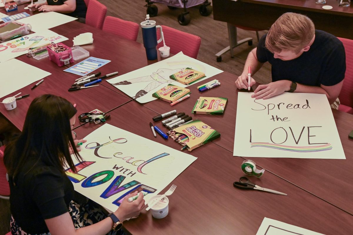 Josh Harker, a graduate student studying social work, and Jenny Tiet, an academic advisor for The College of Design, color pride signs at the PrideFest poster-making event at Talley Student Union on Wednesday, Sept. 24, 2025. The poster-making event is one of the events the Pride Center holds to prepare for PrideFest, which is on Oct. 7.