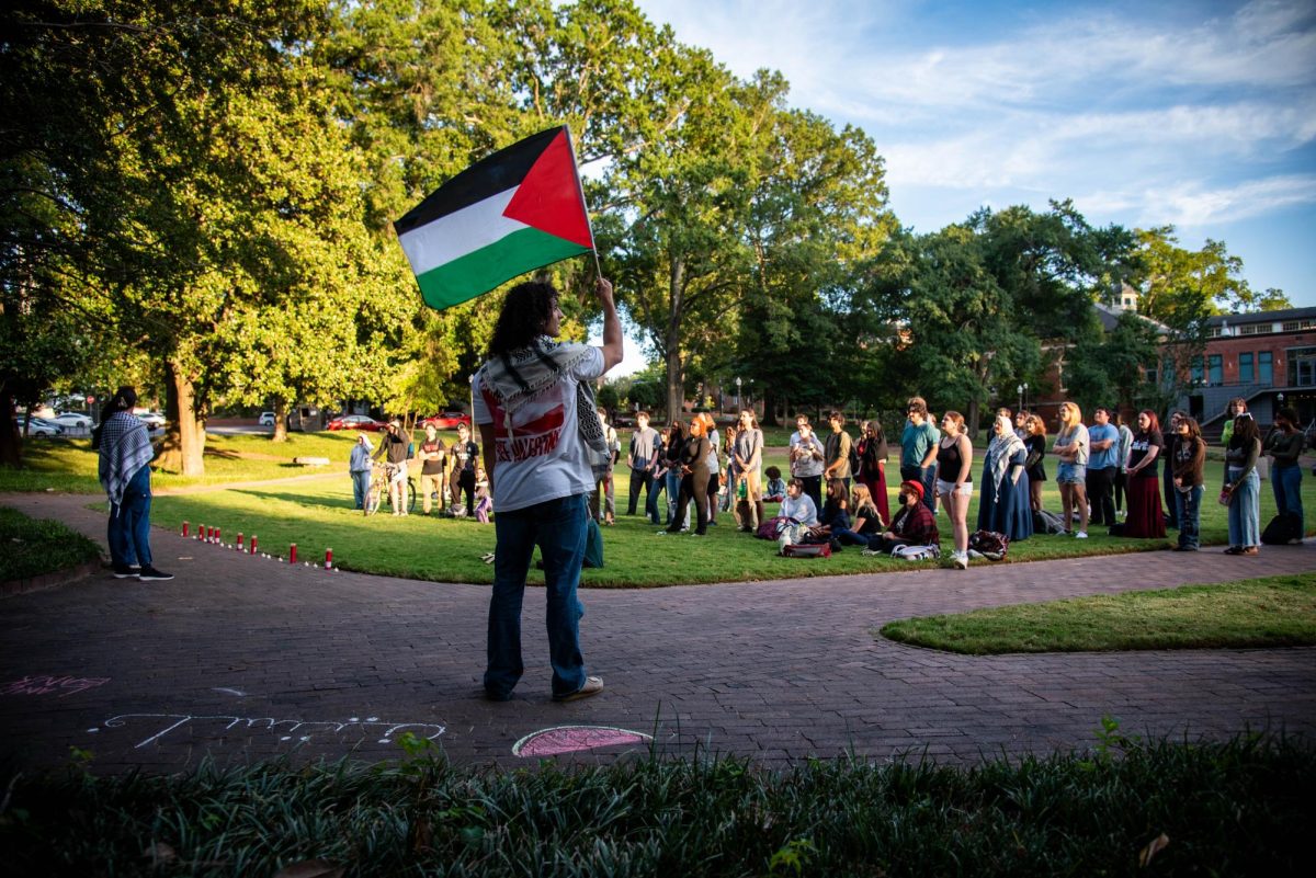 Hashim Ayesh, a graduate in physiology, waves the Palestinian flag during the "There is no Back to School in Gaza" protest in the Court of Carolina on Monday, Sept. 8, 2025. The Group honored students in Gaza and the West Bank with a series of chants and speeches.