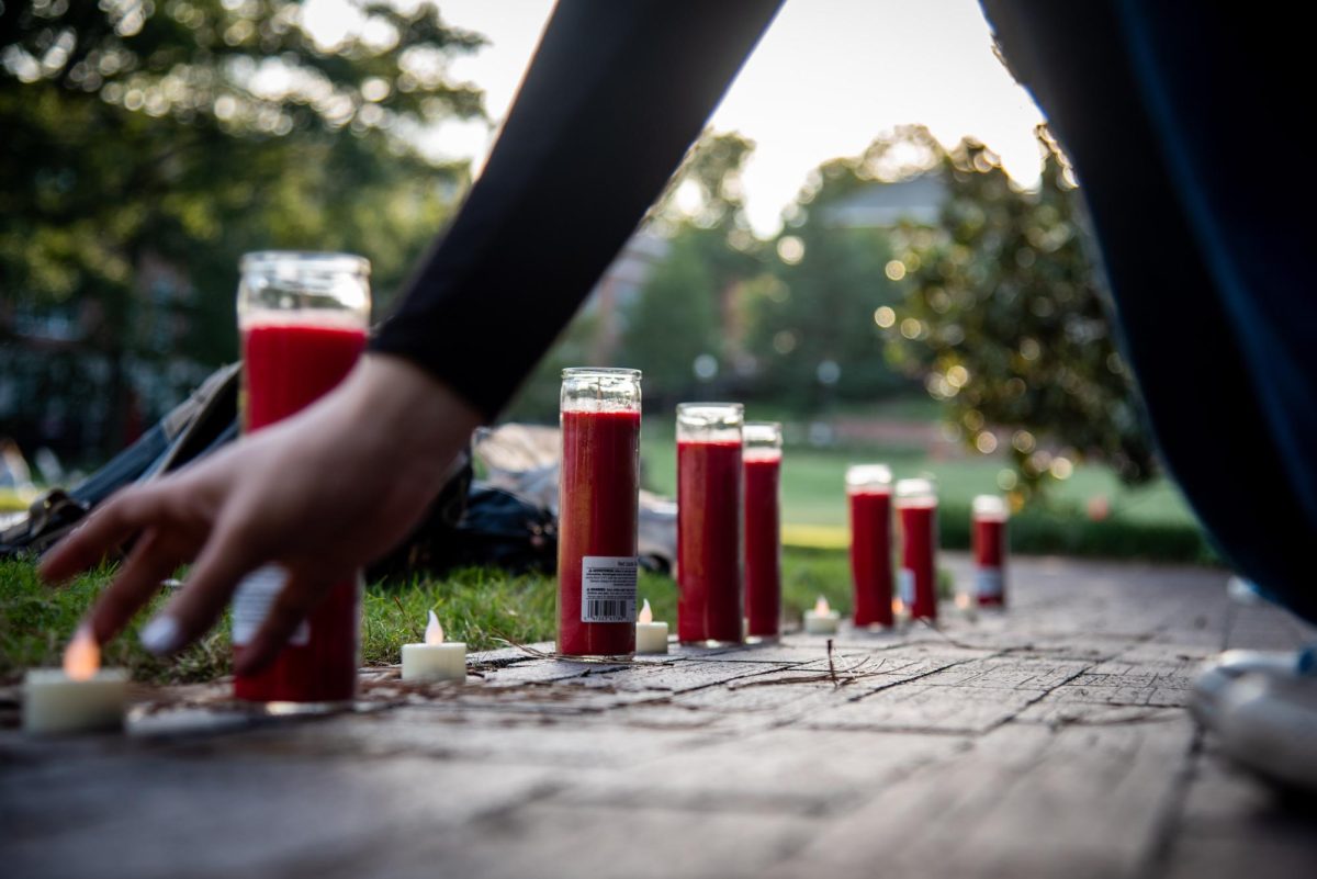 A member of NCSU Students for Justice in Palestine, who declined to give their name, places down candles before the "There is no Back to School in Gaza" protest in the Court of North Carolina on Monday, Sept. 8, 2025. The Group honored students in Gaza and the West Bank with a series of chants and speeches.