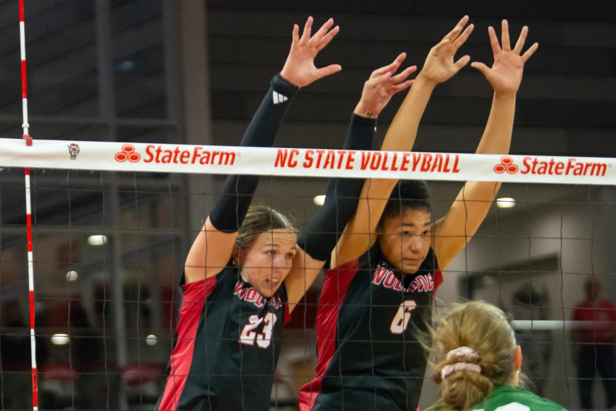 Freshman opposite Jordan Smith and freshman middle blocker Hailey McFadden reach over the net to block during the match against Cleveland State in Reynolds Coliseum on Saturday, Sept. 13, 2025. The Wolfpack defeated the Vikings 3-0.