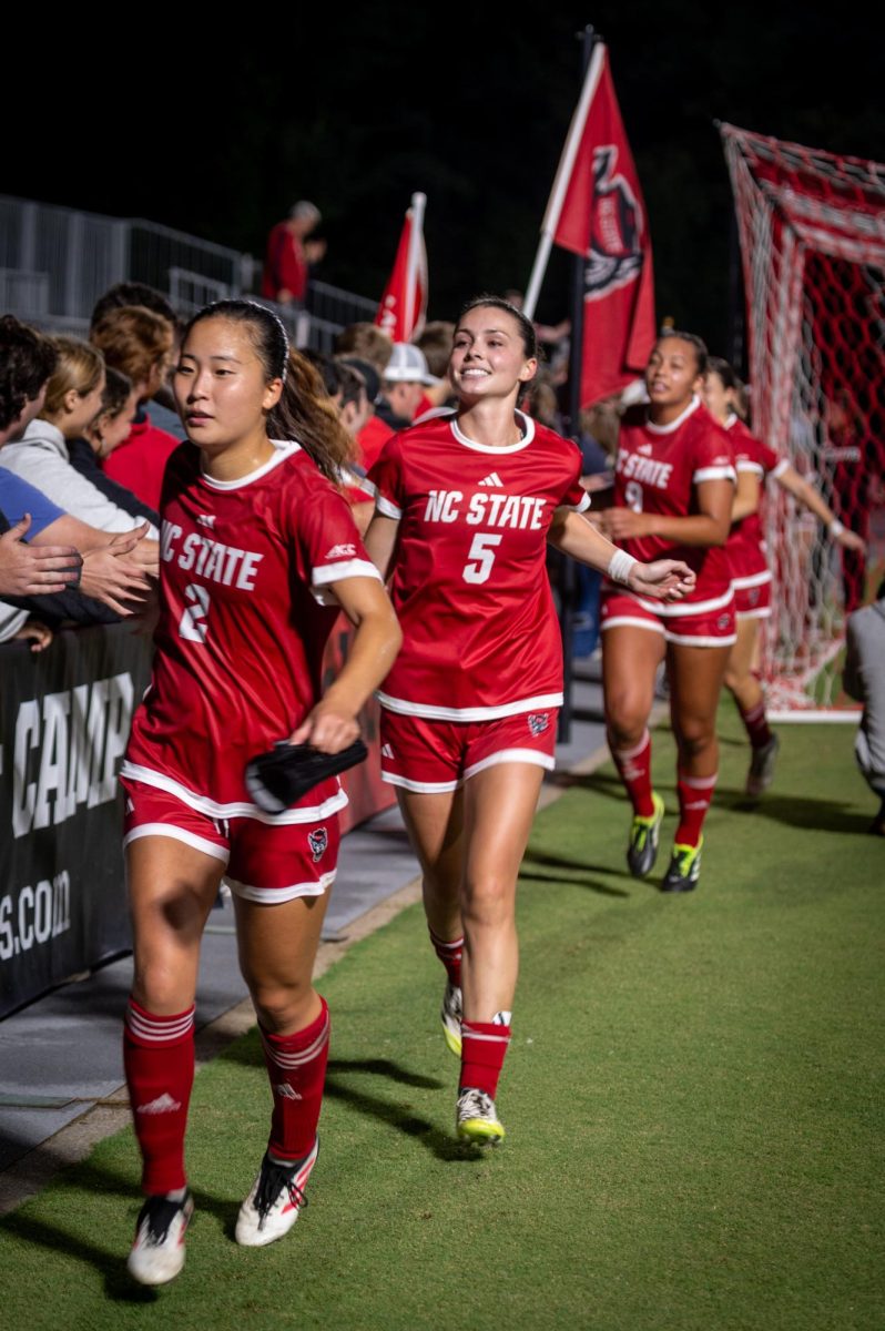 NC State Women's soccer defenders Yuna Aoki and Alex Mohr highfive Red Terrors during the game against Campbell at Dail Soccer Stadium on Sunday, Sept. 7, 2025. The Wolfpack beat the Camels 4-0. 