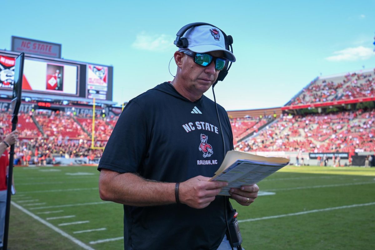 Head coach Dave Doeren reads over plays during the game against the Fighting Camels at Carter-Finley Stadium on Saturday, Oct. 4, 2025. The Wolfpack totaled 371 passing yards. The Wolfpack defeated the Fighting Camels 10-56.