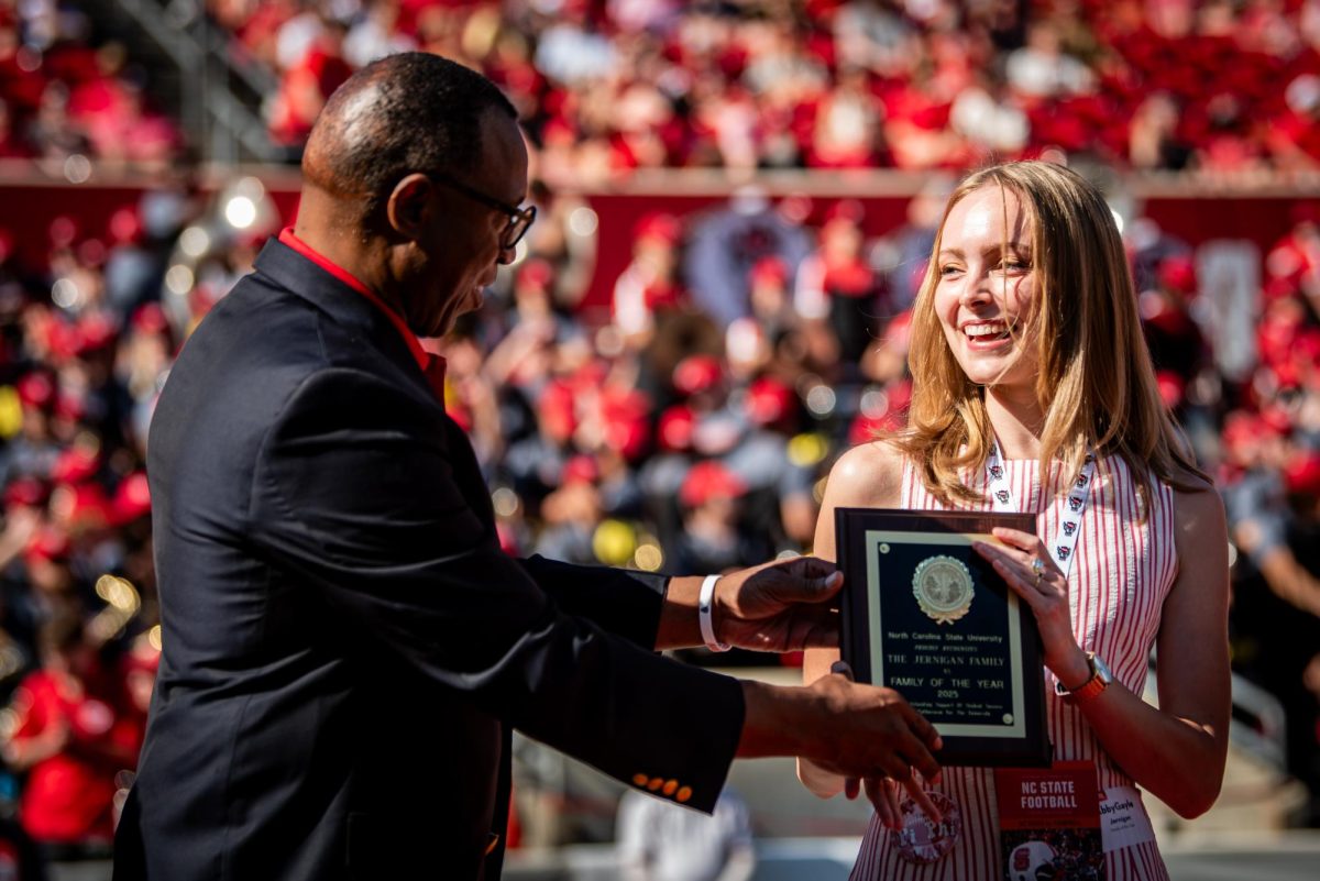 NC State Chancellor Kevin Howell presents the "Family of the Year" award to AbbyGayle Jernigan, a fourth-year in engineering during the game against Campbell in Carter-Finley Stadium on Saturday, Oct. 4, 2025. The Wolfpack beat the Camels 56-10.