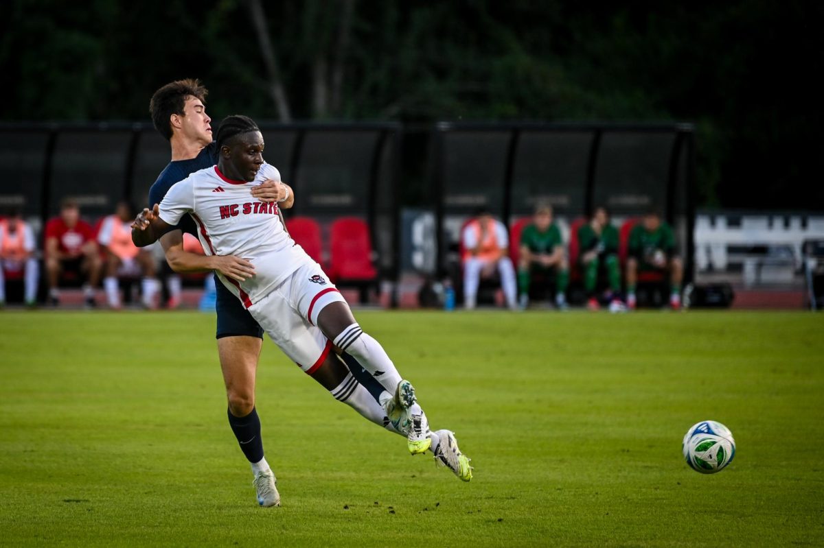 Graduate forward Ibrahim Conde is held up by a Virginia player during the game at Dail Soccer Stadium on Sunday, Oct. 5, 2025. Virginia beat NC State 1-0.