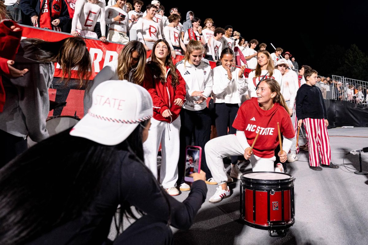 Senior goalkeeper Olivia Pratapas of the NC State Women's Soccer team kneels down to play the drums during the game against Clemson in Dail Soccer Stadium on Friday, Oct. 10, 2025. NC State defeated Clemson 1-0.