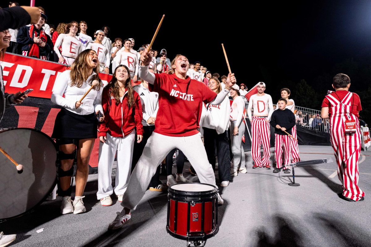Senior goalkeeper Olivia Pratapas of the NC State Women's Soccer team yells after hitting the drum to get the Red Terrors student section hype during the game against Clemson in Dail Soccer Stadium on Friday, Oct. 10, 2025. NC State defeated Clemson 1-0.