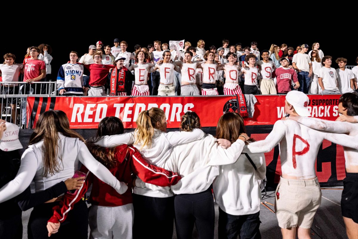 The Red Terrors student section locks arms and sings during a timeout in play during the game against Clemson in Dail Soccer Stadium on Friday, Oct. 10, 2025. NC State defeated Clemson 1-0.
