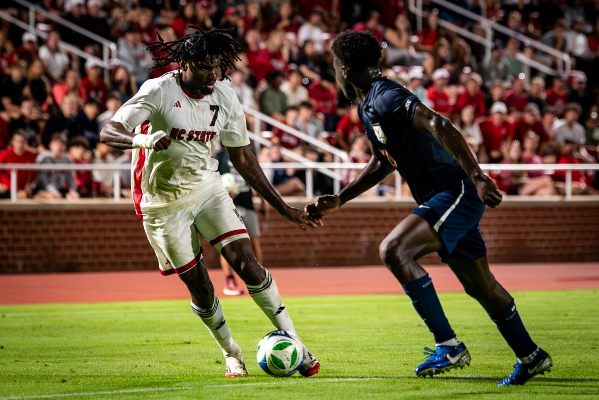 Junior forward Donavan Phillip dribbles the ball during the game against Virginia in Dail Soccer Stadium on Sunday, Oct. 5, 2025. The Cavaliers defeated the Wolfpack 1-0.