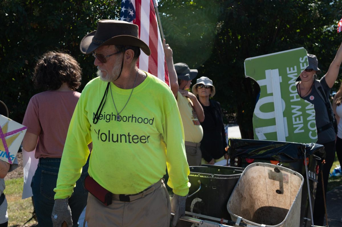 Gus Vandermeeren picks up trash during the No Kings protest on Capital Boulevard in Raleigh, NC, on Saturday, Oct. 18, 2025. Vendermeeren has garnered attention from several local publications as well as state and local governments in recent years for his dedication to cleaning up his community after collecting over 10,000 bags of trash in the Raleigh area.