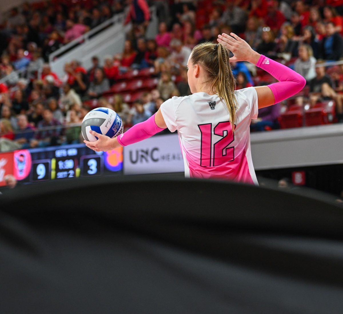 Senior outside hitter Courtney Bryant prepares to serve the ball during the annual Pink Match against Clemson in Reynolds Coliseum on Friday, Oct 17, 2025. NC State beat Clemson 3-1.