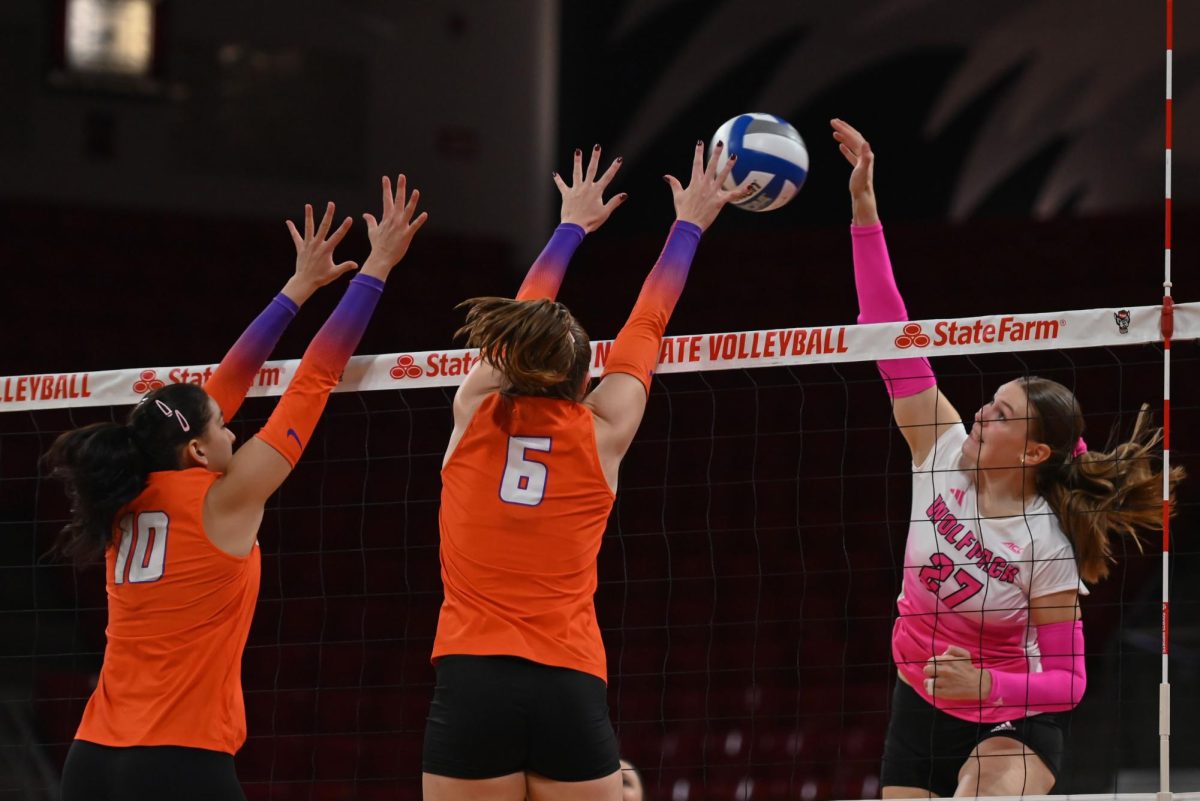Freshman outside hitter Rebecca Ring attempts to hit the ball past the opposing blockers during the annual Pink Match against Clemson in Reynolds Coliseum on Friday, Oct. 17, 2025. Ring ended the match with three blocks and nine kills. The Wolfpack defeated the Tigers 3-1.
